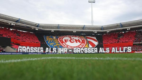 Die Pandemie-Jahre sind nicht nur für den Club keine guten. Nach der Nahtoderfahrung in Ingolstadt und der relativ belanglosen Zweitliga-Zeit mit Zittereinschlag danach ist eine Kulisse wie am zweiten Spieltag gegen den Erstliga-Absteiger aus Fürth im Vergleich dazu wohltuend. Die erfolgreiche Vergangenheit des Altmeisters, die die Heimfans in Nürnberg in prägender Erinnerung haben, projizieren sie im Juli 2022 in ein großflächiges Bild. Ihr Club, so das selbstbewusste Selbstverständnis, sei "größer als ihr, größer als alles".