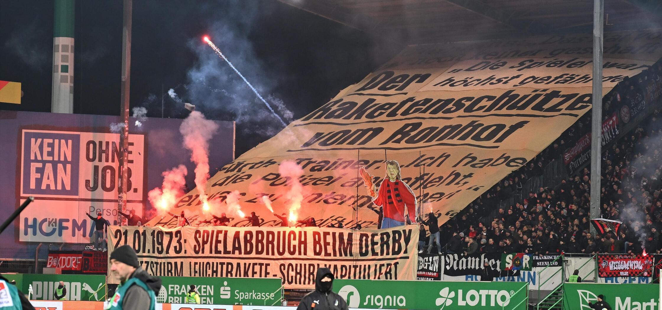 Beim Flutlicht-Rückspiel im abendlichen Ronhof erinnert die aktive Fanszene des FCN an das Raketenabbruchderby in Fürth, das da 50 Jahre zurückliegt. 1973 war der Club in der Nachbarstadt bereits 0:4 hinten und arbeitete sich auf 2:4 heran. Weil der Schiedsrichter nach dem Beschuss des Feldes und der Wahrnehmung eines erneut drohenden Platzsturms bald darauf genug hatte, hatten die Kontrahenten vorzeitig Feierabend. Dem Kleeblatt wurde im Nachgang ein 2:0-Sieg zugesprochen,