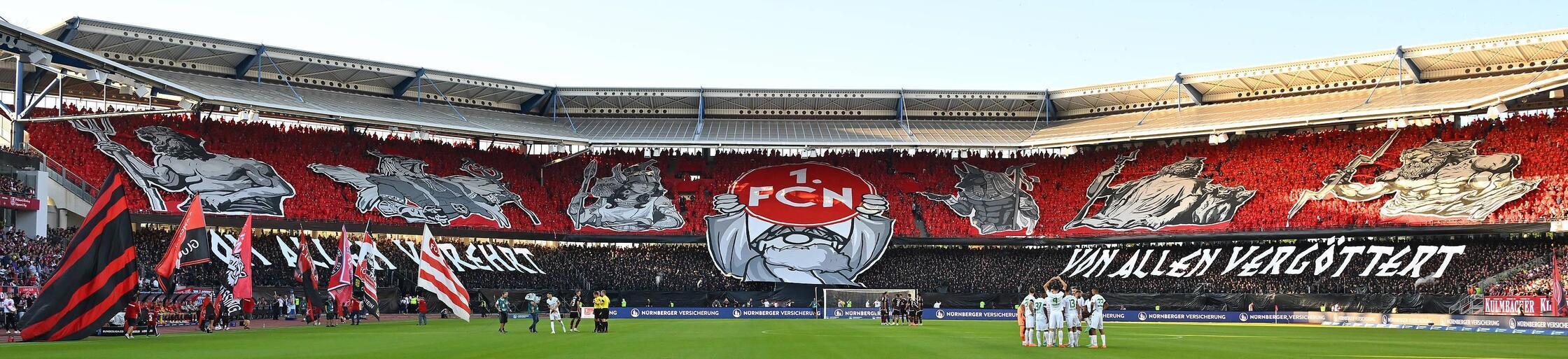 Mit einer mythologischen Breitseite empfangen die Club-Fans die Spielvereinigung beim bislang letzten Derby in Nürnberg. Und auch Can Uzun, Nürnbergs Halbgott in dieser Saison. Im Achteck verwandelt dieser aus elf Metern kurz vor der Pause nervenstark vom Punkt. Ein 1:1 steht auch am Ende des abseits starker Bilder nicht unbedingt göttergleichen Kräftemessens im September 2023. Eine gewisse Rasanz war in der Begegnung gleichwohl spürbar gewesen.