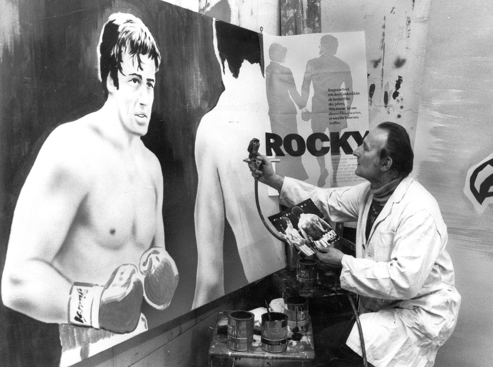 Mit geschultem Blick und einer Sprühpistole in der Hand erweckte Nürnbergs einziger und letzter Filmplakatmaler im Jahr 1977 eine überlebensgroße Boxkampfszene aus dem Film „Rocky“ auf einer Hartfaserplatte zum Leben. Jedes Werbeplakat, das der gelernte Kirchenmaler Herbert Koch in satten Farben gestaltete, war ein Unikat. Auf dem Höhepunkt des Kinobooms in den 50er und 60er Jahren war er für sage und schreibe dreißig Kinobetreiber im Nürnberger Raum künstlerisch tätig, Ende der 70er Jahre nur noch für drei: die Filmplakatmalerei wurde zur aussterbenden Kunst.
