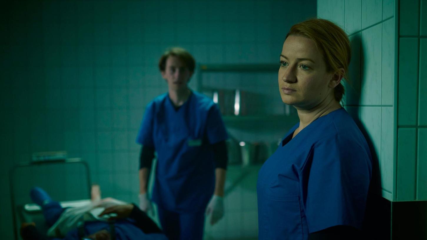 Im ZDF-Krimi "Theresa Wolff - Lost" steckt Nina Gummich (rechts) als Gerichtsmedizinerin Theresa Wolff in einer gefährlichen Lage: Sie und ihre Kollegen wegen als Geiseln genommen. Im ZDF-Krimi "Theresa Wolff - Lost" steckt Nina Gummich (rechts) als Gerichtsmedizinerin Theresa Wolff in einer gefährlichen Lage: Sie und ihre Kollegen wegen als Geiseln genommen.