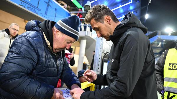 Trainer Miroslav Klose verteilt vor Anpfiff noch Autogramme.