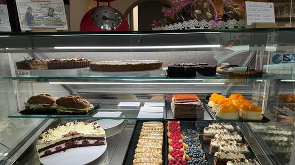Die Kuchen, Schnitten und Torten wechseln täglich. Ab und zu schauen Kunden nur kurz herein, um zu evaluieren, ob sich ein Besuch diese Woche für sie lohnt, oder sie lieber auf die Auswahl der kommenden warten.