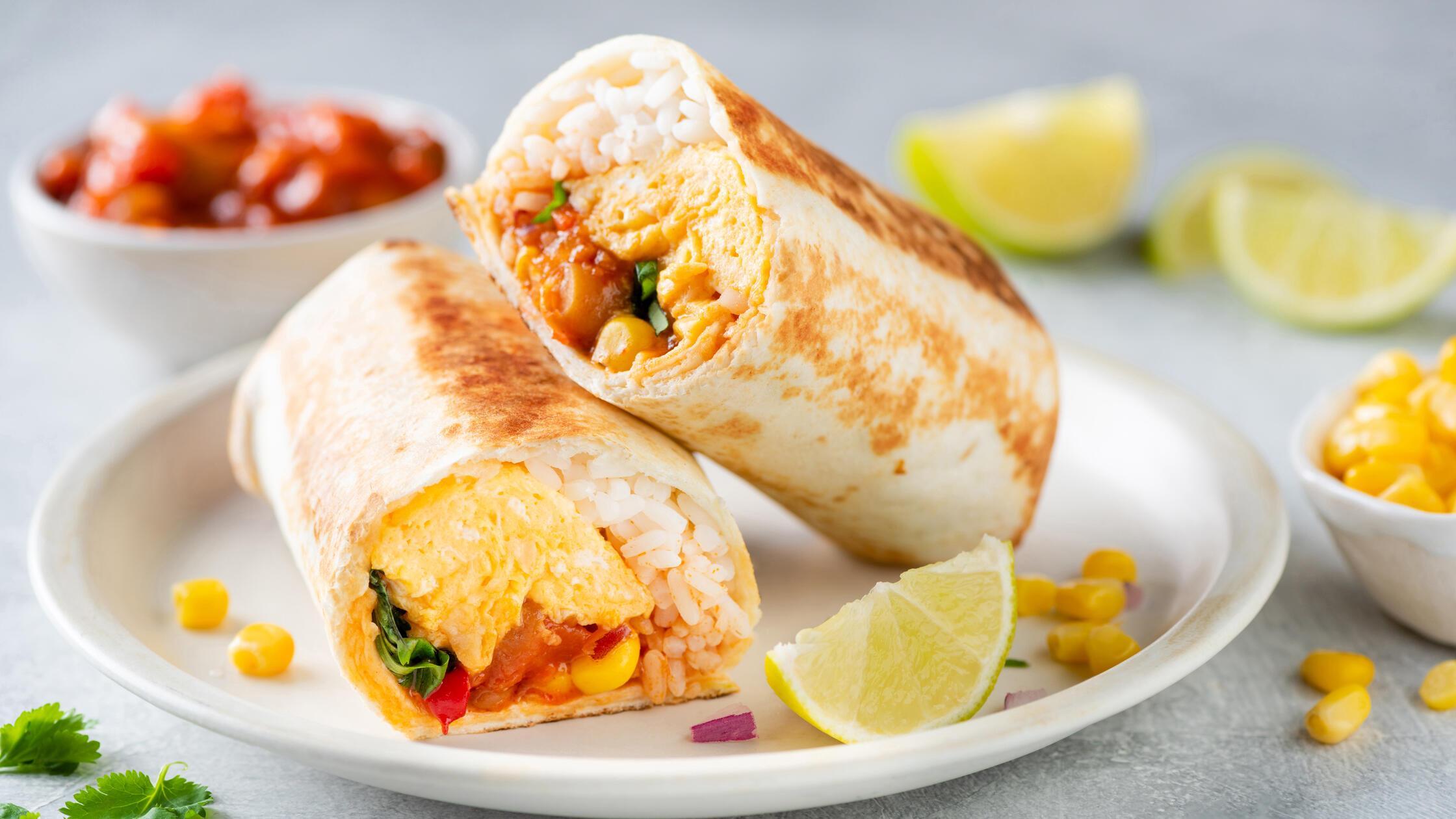Breakfast vegetarian burrito wrap with omelette an