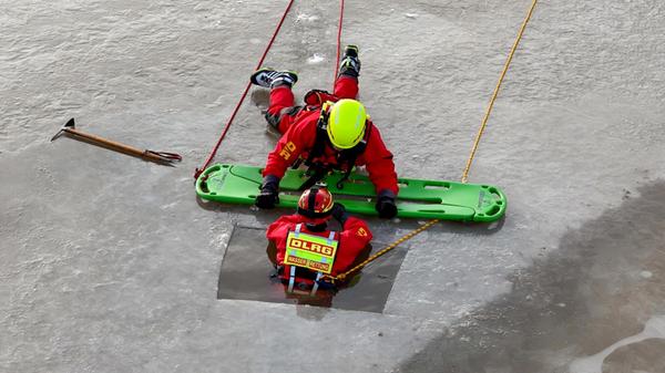 Mit der richtigen Schutzbekleidung ausgerüstet, geht es dann für die Mitglieder DLRG ans Eingemachte. Immer wieder begibt sich einer von Ihnen zur Erprobung des Ernstfalls in ein Loch im sonst zugefrorenen Weiher und lässt sich von seinen Kollegen auf verschiedene Arten retten. Ohne die Schutzkleidung wäre die Übung für die Mitglieder der DLRG Ansbach lebensgefährlich.