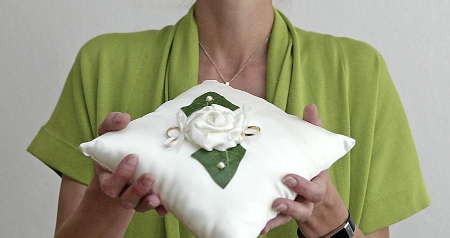 Das Kissen für die Eheringe gehört ebenso zu den gut gehüteten Requisiten der „Ritualfrau“ wie ein zweiteiliger Kelch in Herzform und dekorative Bänder.