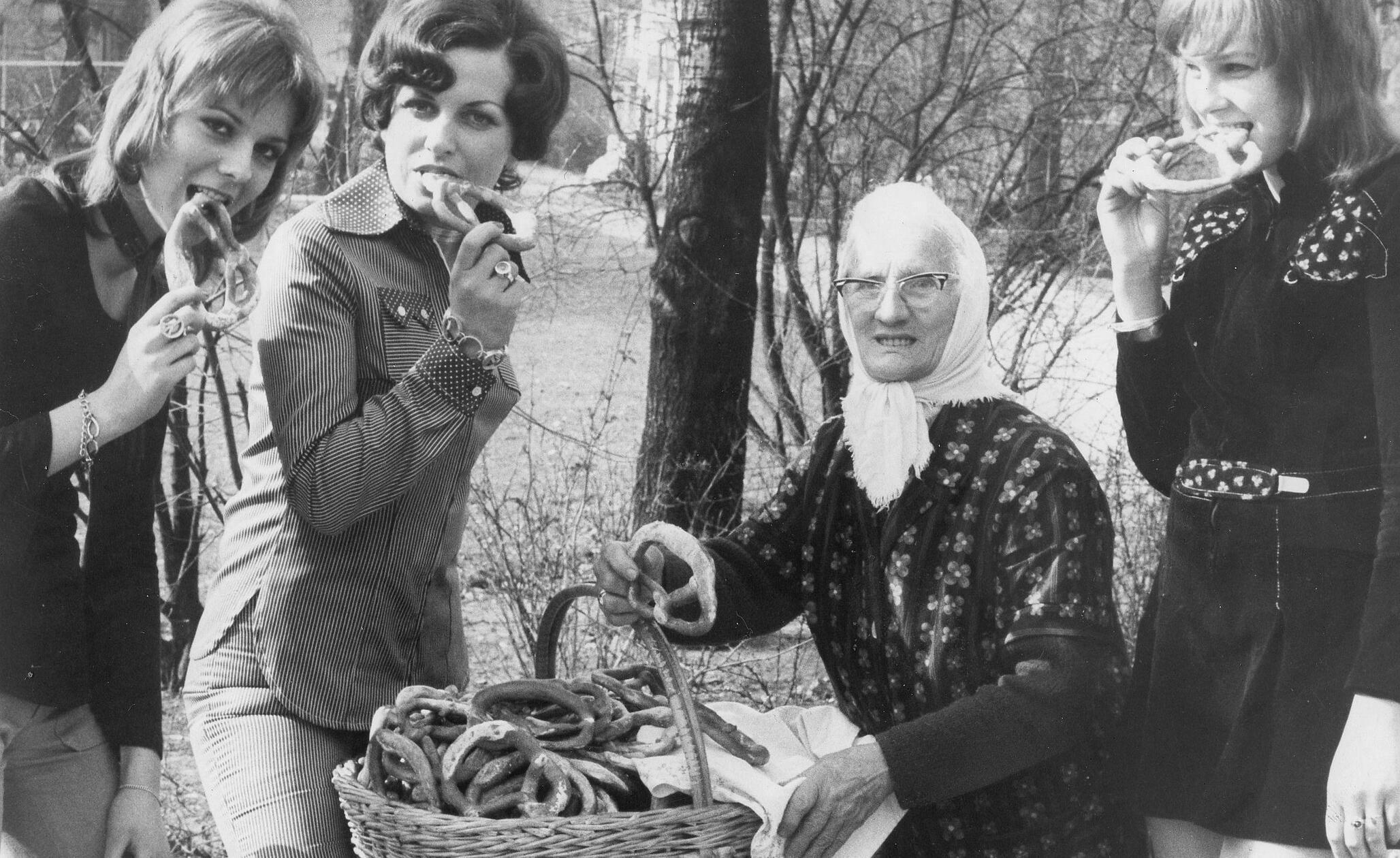 „Mädchen sind nicht mehr toupiert“ meldete die NN im März 1972 zu diesem Bild. Die Friseurinnung hatte die neuen Modefrisuren vorgestellt. Mädchen bis 19 Jahre sollten nun einen Schnitt erhalten, bei dem lästiges Sitzen unter der Trockenhaube wegfiel. Die Frisur mit kurzem Oberkopfhaar und langer Nackenpartie brauchte nur geföhnt zu werden. Sie ging unter dem Namen „Vokuhila“ (vorne kurz, hinten lang) in die Geschichte ein. Frauen bis 30 wurden große, natürliche Wellen empfohlen, wobei das Haar im Nacken eine füllige Innenrolle bildete. Von all dem völlig ungerührt trug die Brezenfrau im Stadtpark weiterhin ihr Kopftuch.