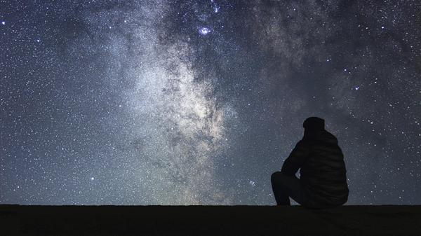 Mann schaut in den Sternenhimmel. Alleinstehender