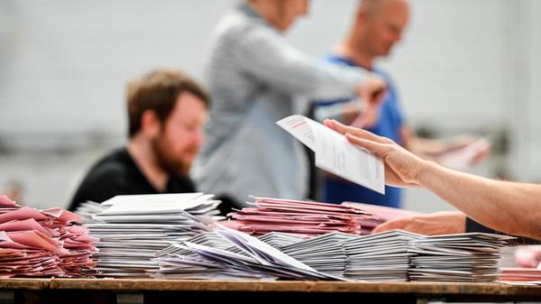 Wahlhelfer in der Messe Essen sortieren die Brief