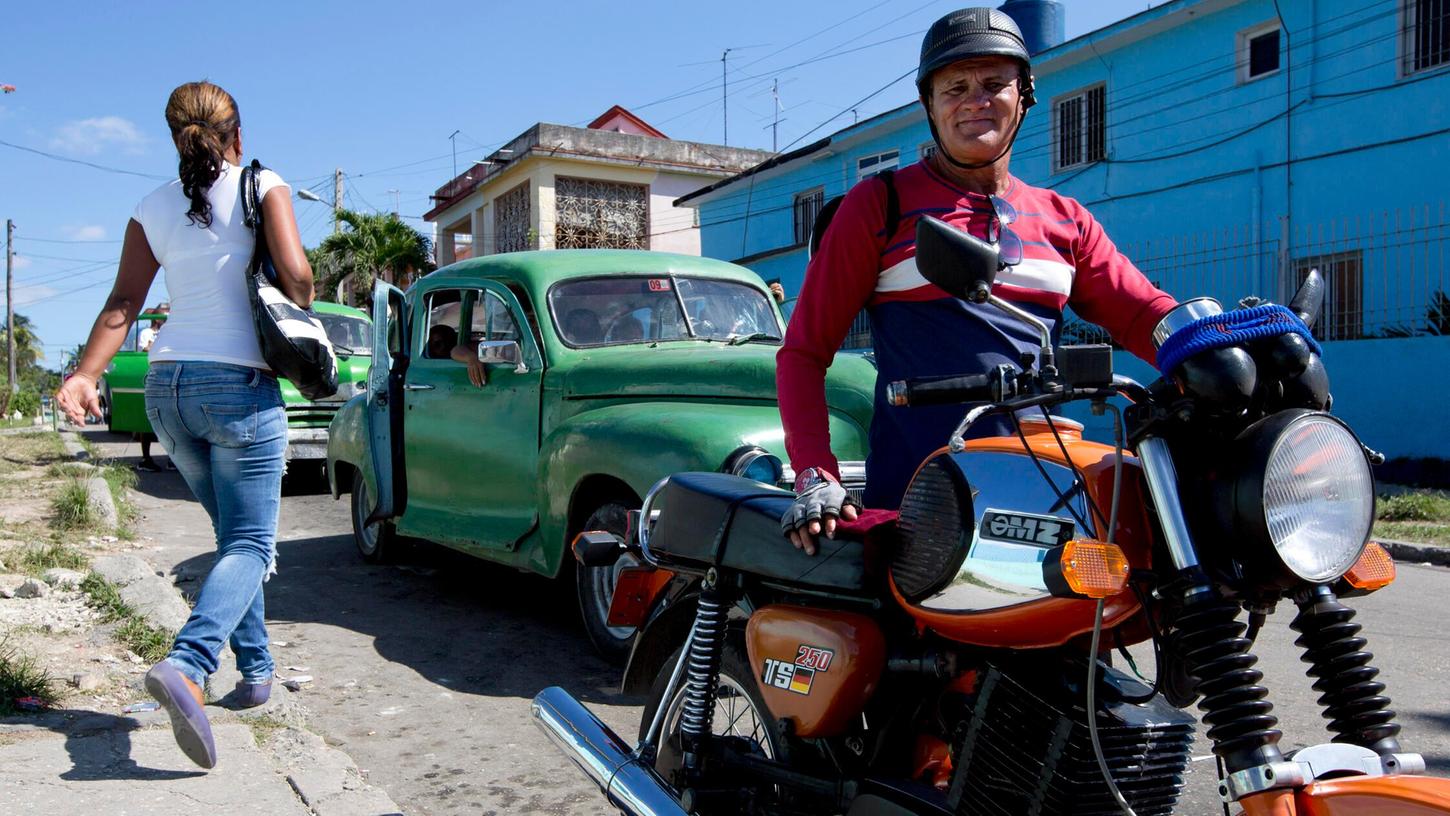 Ein Taxifahrer mit seinem MZ-Motorrad im Stadtviertel La Palma (Havanna). In Deutschland findet man sie kaum noch, in dem Karibikstaat sind ostdeutsche Zweiräder nach wie vor beliebt - in Großstädten sind Tausende sogar als öffentliche Verkehrsmittel im Einsatz. Ein Taxifahrer mit seinem MZ-Motorrad im Stadtviertel La Palma (Havanna). In Deutschland findet man sie kaum noch, in dem Karibikstaat sind ostdeutsche Zweiräder nach wie vor beliebt - in Großstädten sind Tausende sogar als öffentliche Verkehrsmittel im Einsatz.