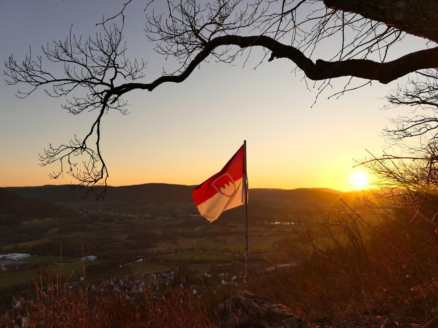 Die Frankenflagge weht im Sonnenuntergang, fotografiert von der Geißkirche in Hohenstadt aus.