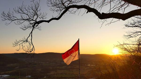 Die Frankenflagge weht im Sonnenuntergang, fotografiert von der Geißkirche in Hohenstadt aus.