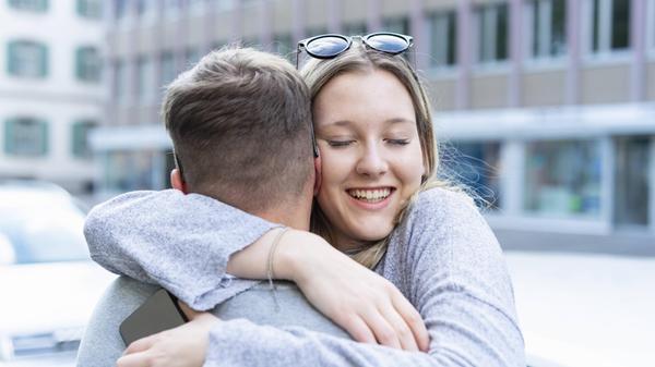 Portrait of happy young woman hugging her boyfrien