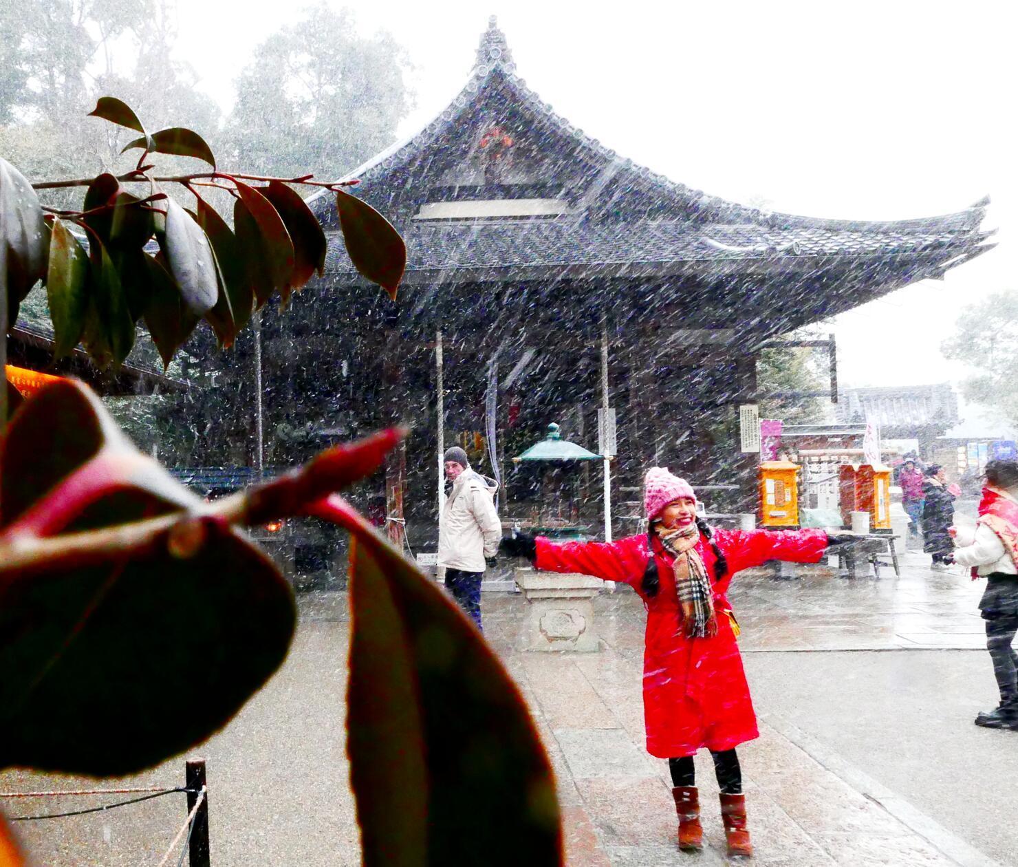 Diese junge Frau genießt den plötzlichen Schneefall.