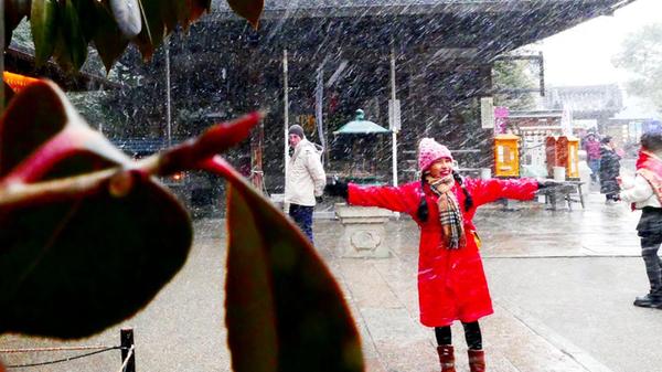 Diese junge Frau genießt den plötzlichen Schneefall.