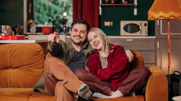 Couple sitting on couch at home model released, Sy