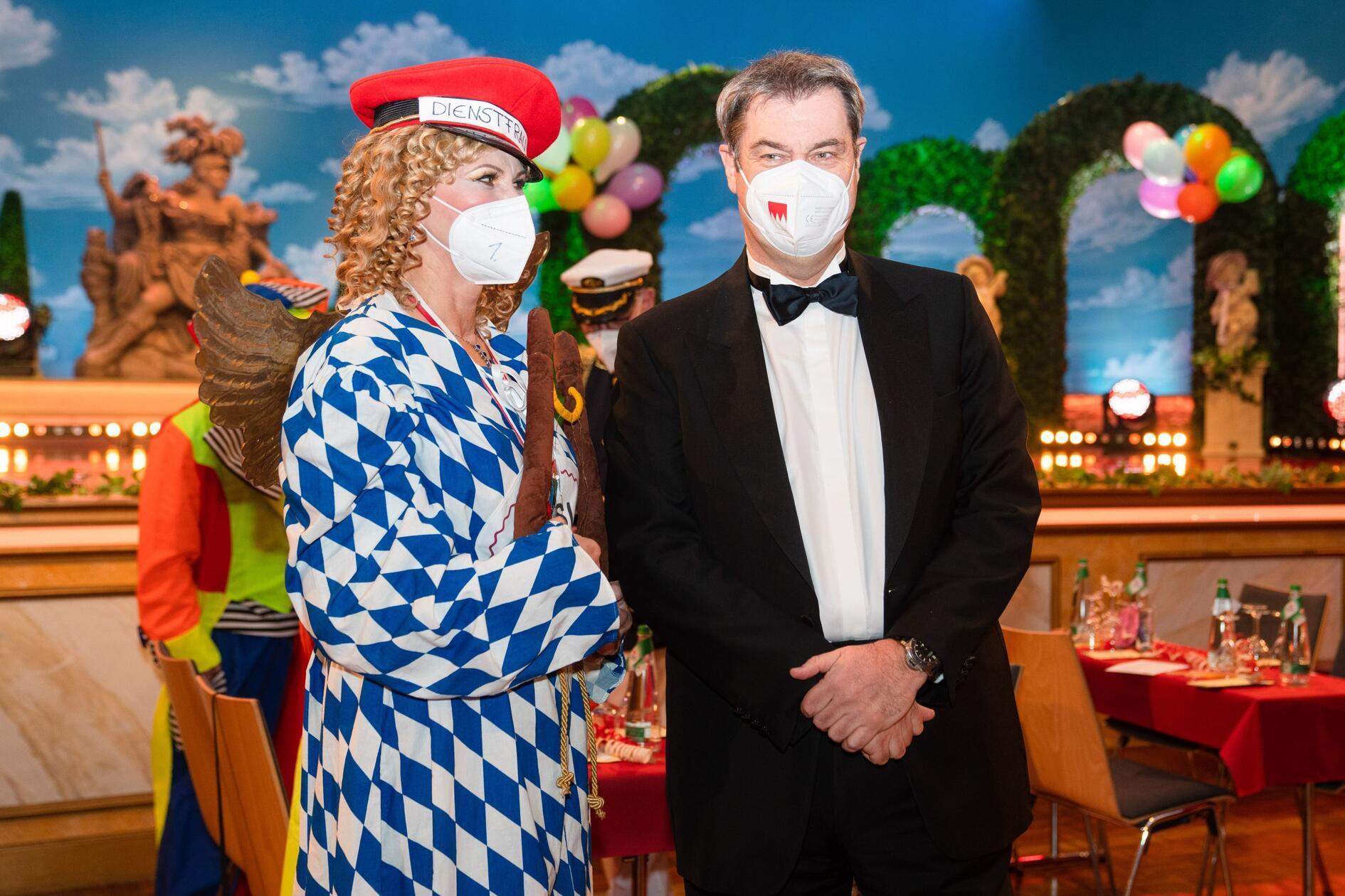 Auch mit FFP2-Maske will Söder 2022 seine Liebe zu Franken zum Ausdruck bringen. Ilse Aigner steht an seiner Seite und trägt einen Blazer in Bayerns Farben. Im Jahr 2021 fand die Show dann wegen der Pandemie ohne Publikum im Saal statt.