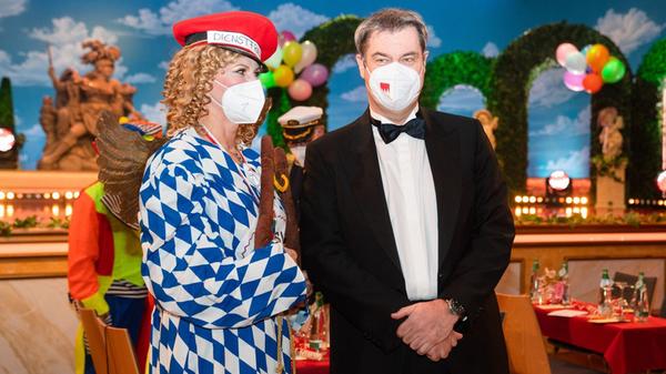 Während die bayerische Landtagspräsidentin Ilse Aigner mit einem Blazer im Bayern-Look posiert, setzt Söder mit seiner FFP2-Maske auf Heimatverbundenheit. 2022 fand "Fastnacht in Franken" mit Corona-Einschränkungen statt - 2021 noch ohne Publikum.
