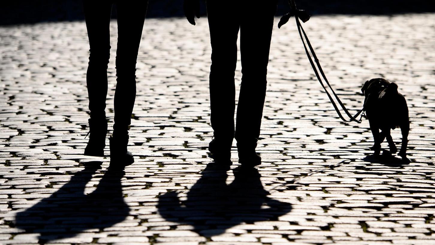 Fußgänger gehen mit einem Hund an der Leine spazieren (Symbolbild). In Gunzenhausen ist nun ein Streit unter Hundebesitzern eskaliert. Fußgänger gehen mit einem Hund an der Leine spazieren (Symbolbild). In Gunzenhausen ist nun ein Streit unter Hundebesitzern eskaliert.