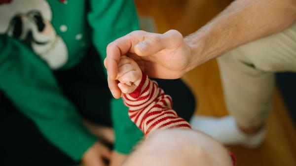 Familienmomente mit der winzigen Hand eines Babys