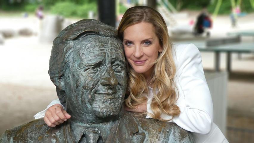 Erinnerungen an ein Original des Fernsehens und der Stadt München: Moderatorin Caro Matzko am Denkmal für Helmut Fischer als Monaco Franze vor dem Café "Münchner Freiheit". Erinnerungen an ein Original des Fernsehens und der Stadt München: Moderatorin Caro Matzko am Denkmal für Helmut Fischer als Monaco Franze vor dem Café "Münchner Freiheit".