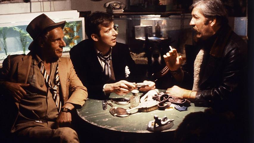 Was für eine Runde: Nach seiner Entlassung aus dem Gefängnis plant der Tierpark-Toni (Wolfgang Fierek, Mitte) zusammen mit seinen Kumpanen (Herb Andress, links, und Carlheinz Heitmann), auf welche Weise er sich am besten an Kriminalkommissar Münchinger, seinem "Erzfeind", rächen könnte. Was für eine Runde: Nach seiner Entlassung aus dem Gefängnis plant der Tierpark-Toni (Wolfgang Fierek, Mitte) zusammen mit seinen Kumpanen (Herb Andress, links, und Carlheinz Heitmann), auf welche Weise er sich am besten an Kriminalkommissar Münchinger, seinem "Erzfeind", rächen könnte.