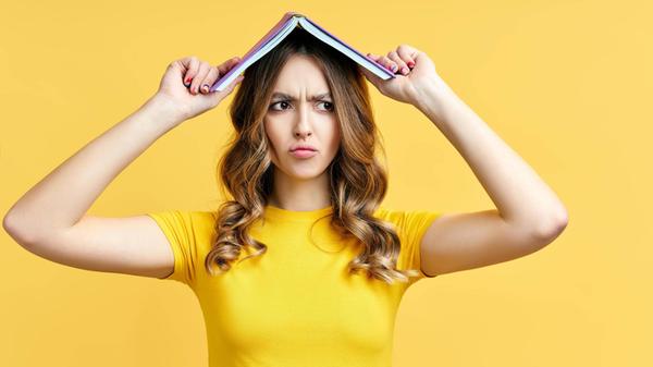 Foto einer lustigen Frau, die ein Buch über den Ko