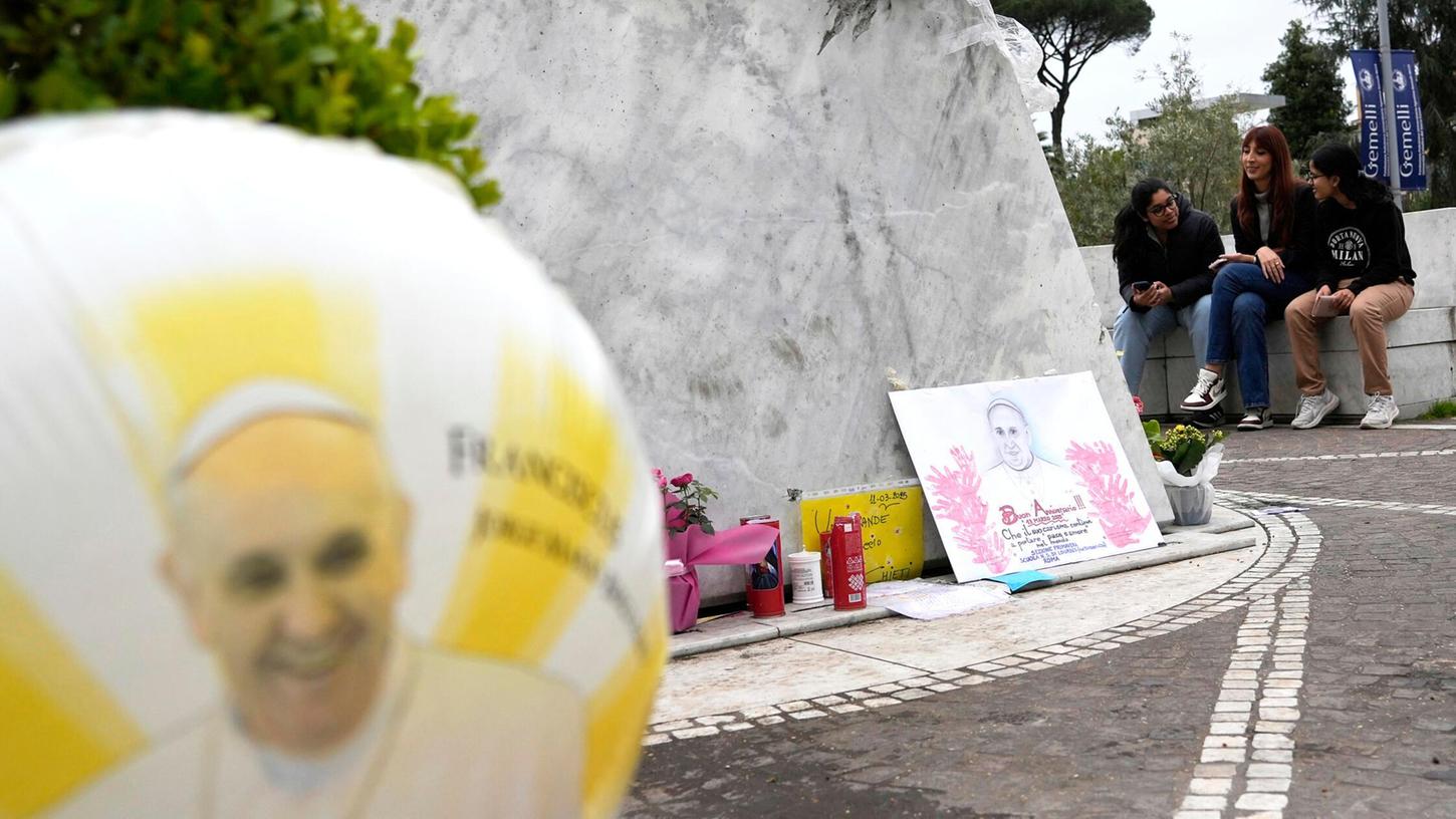 Ein Ballon und eine Zeichnung von Papst Franziskus sind vor der Poliklinik Agostino Gemelli zu sehen, wo der Papst seit Freitag, 14. Februar, im Krankenhaus liegt. Ein Ballon und eine Zeichnung von Papst Franziskus sind vor der Poliklinik Agostino Gemelli zu sehen, wo der Papst seit Freitag, 14. Februar, im Krankenhaus liegt.
