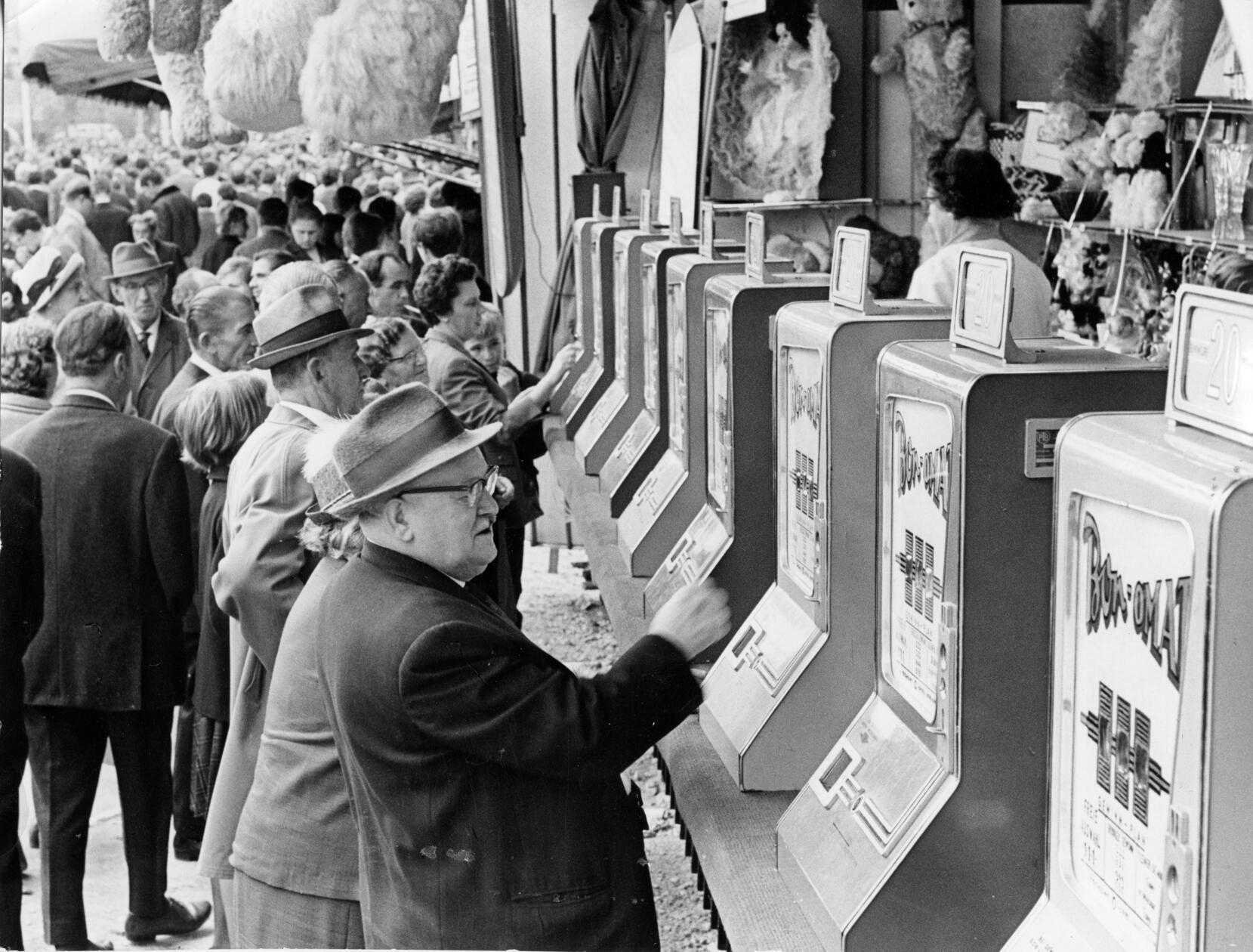 Auch das 140. Nürnberger Herbstvolksfest im Jahre 1966 lockte Tausende von Menschen aus weiten Teilen Frankens an, die sich amüsieren, Bratwürste essen und das eigens gebraute Festbier trinken wollten. Neben den üblichen Fahr- und Schaugeschäften waren auch Spielautomaten Teil des damaligen Angebots. Dauerhaft haben sie die noch heute anzutreffenden Losverkäufer nicht ersetzt, damals war der Knopfdruck am „Bon-omat“ jedoch eine beliebte und moderner anmutende Alternative für jene, die ihr Glück herausfordern wollten. Auch wenn nicht immer eine Gewinn-Nummer ausgegeben wurde, so war die Nachfrage offensichtlich groß.
