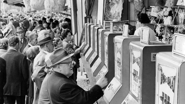 Auch das 140. Nürnberger Herbstvolksfest im Jahre 1966 lockte Tausende von Menschen aus weiten Teilen Frankens an, die sich amüsieren, Bratwürste essen und das eigens gebraute Festbier trinken wollten. Neben den üblichen Fahr- und Schaugeschäften waren auch Spielautomaten Teil des damaligen Angebots. Dauerhaft haben sie die noch heute anzutreffenden Losverkäufer nicht ersetzt, damals war der Knopfdruck am „Bon-omat“ jedoch eine beliebte und moderner anmutende Alternative für jene, die ihr Glück herausfordern wollten. Auch wenn nicht immer eine Gewinn-Nummer ausgegeben wurde, so war die Nachfrage offensichtlich groß.