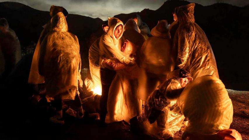 Chinesische Migranten wärmen sich im kalten Regen auf, nachdem sie die Grenze zwischen den USA und Mexiko überquert haben. Das Bild wurde von dem US-amerikanischen Fotografen John Moore für Getty Images aufgenommen. Chinesische Migranten wärmen sich im kalten Regen auf, nachdem sie die Grenze zwischen den USA und Mexiko überquert haben. Das Bild wurde von dem US-amerikanischen Fotografen John Moore für Getty Images aufgenommen.