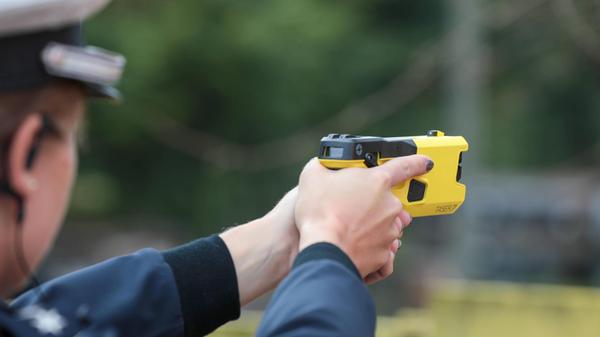 Themenbild Polizei mit Tasern Eine Polizistin ziel