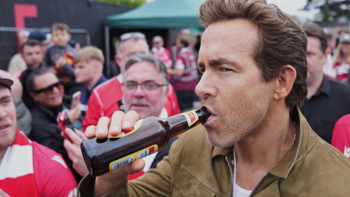 Schauspieler Ryan Reynolds lässt sich vor dem Spiel seines Clubs AFC Wrexham ein Bier schmecken. Schauspieler Ryan Reynolds lässt sich vor dem Spiel seines Clubs AFC Wrexham ein Bier schmecken.