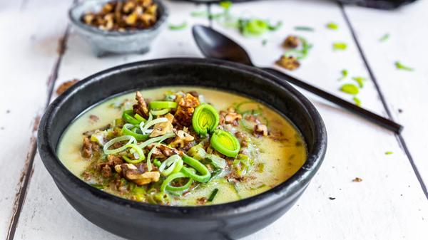 Bowl of vegetarian leek soup with cheese and roast