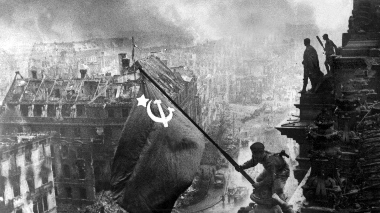 Der sowjetische Soldat Militon Kantarija aus Georgien hisst am 2. Mai 1945 die sowjetische Flagge auf dem Berliner Reichstag. Deutschland hatte den Zweiten Weltkrieg verloren. Der sowjetische Soldat Militon Kantarija aus Georgien hisst am 2. Mai 1945 die sowjetische Flagge auf dem Berliner Reichstag. Deutschland hatte den Zweiten Weltkrieg verloren.