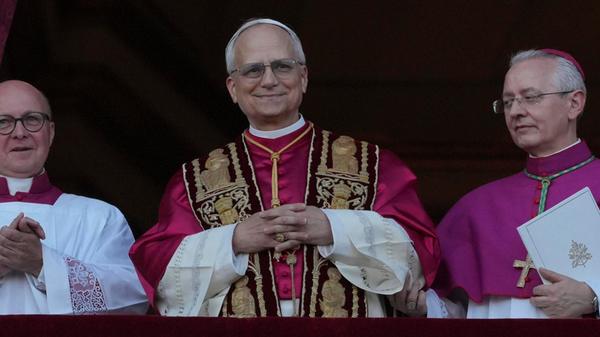 Der neu gewählte Papst Leo XIV., US-Amerikaner Robert Prevost, lächelt als Heiliger Vater vom Balkon auf den Petersplatz zu den Gläubigen hinab.