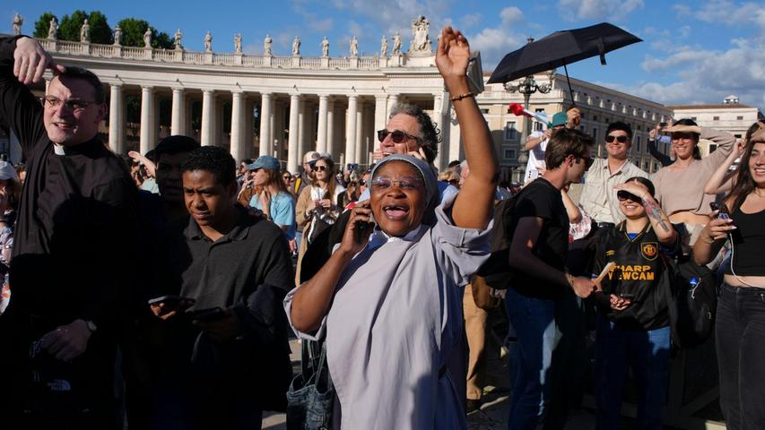Gläubige telefonieren mit ihren Angehörigen, um vom neuen Papst zu berichten. Gläubige telefonieren mit ihren Angehörigen, um vom neuen Papst zu berichten.