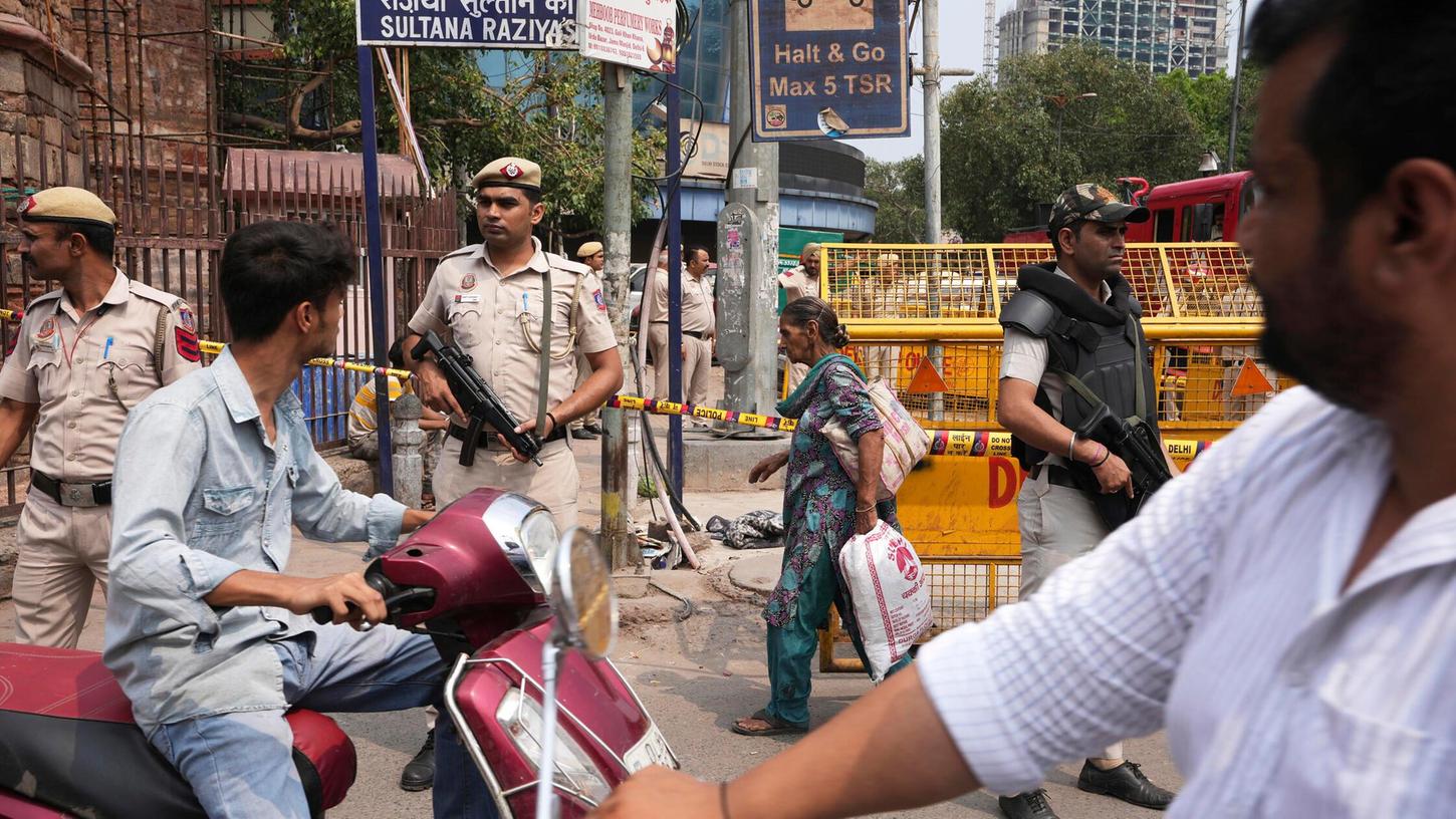 Ein Polizist hält Wache auf einer belebten Straße im alten Viertel von Neu-Delhi. Ein Polizist hält Wache auf einer belebten Straße im alten Viertel von Neu-Delhi.