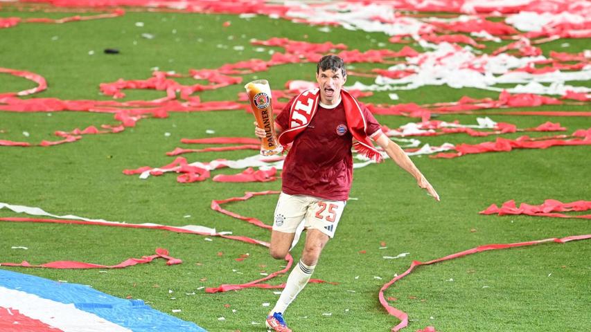 Thomas Müller rennt bei der Meisterfeier mit Bier über das Feld. Thomas Müller rennt bei der Meisterfeier mit Bier über das Feld.