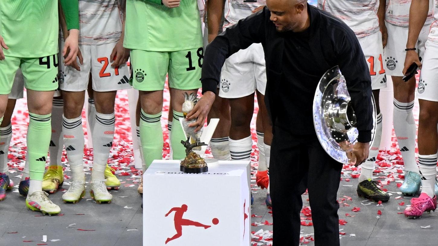Bayern-Trainer Vincent Kompany stellt bei der Meisterparty eine Kakadu-Figur auf den Sockel. Bayern-Trainer Vincent Kompany stellt bei der Meisterparty eine Kakadu-Figur auf den Sockel.