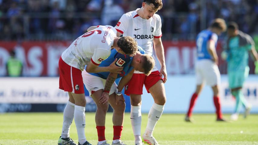 Kiels Lewis Holtby wird nach dem Abstieg von den Freiburgern Patrick Osterhage (l) und Maximilian Eggestein getröstet. Kiels Lewis Holtby wird nach dem Abstieg von den Freiburgern Patrick Osterhage (l) und Maximilian Eggestein getröstet.