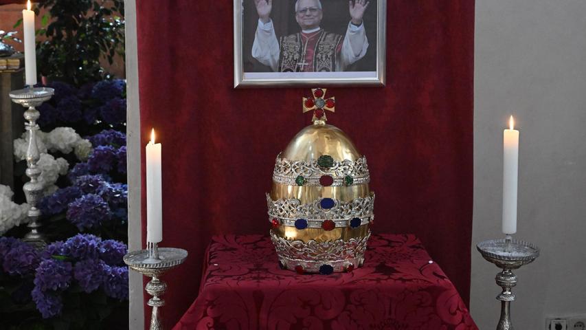 In der Münchner Stadtpfarrkirche ist die Tiara der Petrusfigur vor einem Bild des neuen Papstes Leo XIV. zu sehen. In der Münchner Stadtpfarrkirche ist die Tiara der Petrusfigur vor einem Bild des neuen Papstes Leo XIV. zu sehen.