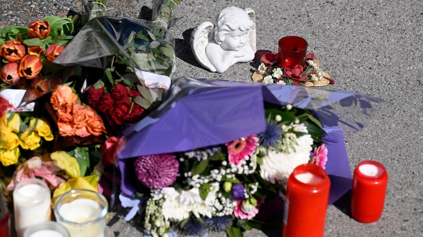 Zeichen der Anteilnahme: Auf einem Bürgersteig an dem Spielplatz sind Kerzen und Blumen niedergelegt worden. Zeichen der Anteilnahme: Auf einem Bürgersteig an dem Spielplatz sind Kerzen und Blumen niedergelegt worden.