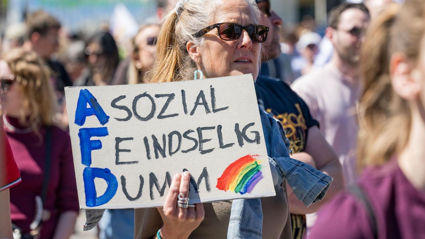 Eine Demonstrantin hält ein Plakat mit der Aufschrift „Asozial - Feindselig - Dumm“ bei einer Demonstration gegen die AfD in München hoch. Eine Demonstrantin hält ein Plakat mit der Aufschrift „Asozial - Feindselig - Dumm“ bei einer Demonstration gegen die AfD in München hoch.