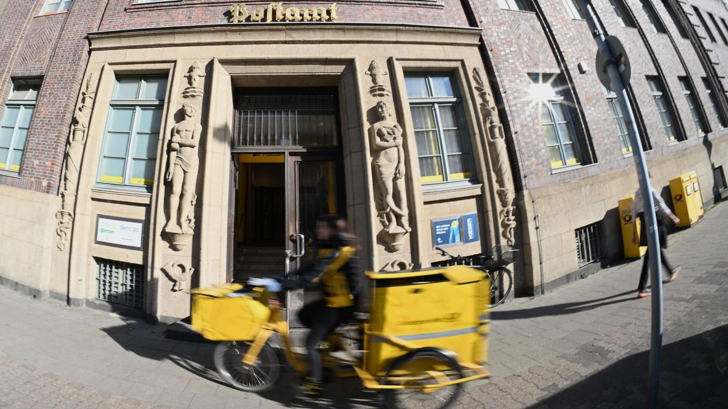 Eine Briefträgerin fährt an einer Postfiliale vorbei - vielleicht ist auch sie eine Beamtin? Eine Briefträgerin fährt an einer Postfiliale vorbei - vielleicht ist auch sie eine Beamtin?