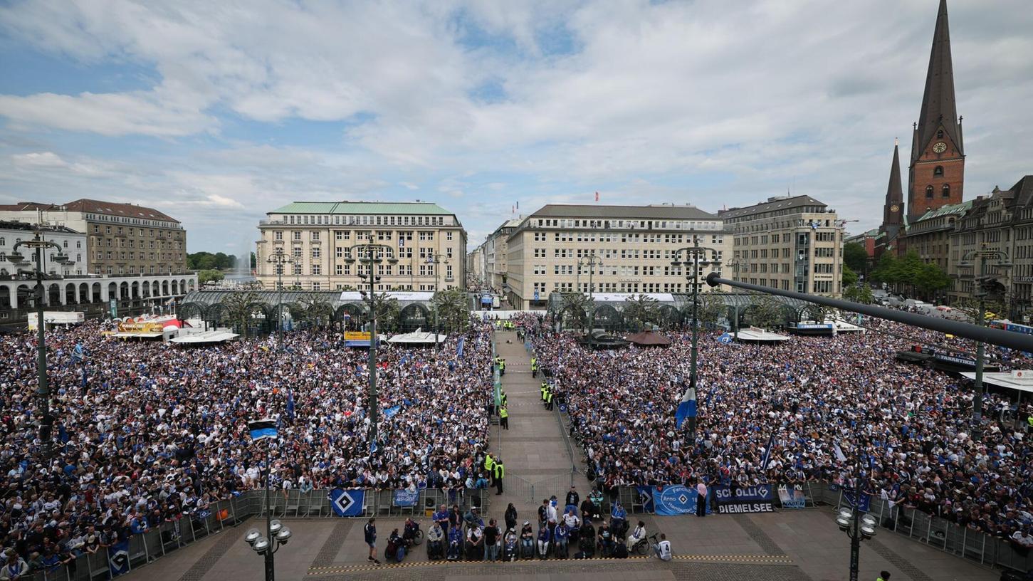 HSV-Fans stehen auf dem Rathausmarkt vor dem Hamburger Rathaus und feiern ihren Club. HSV-Fans stehen auf dem Rathausmarkt vor dem Hamburger Rathaus und feiern ihren Club.