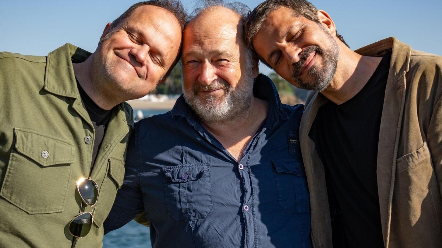 Schauspieler Pasquale Aleardi (rechts), der Schriftsteller Jean-Luc Bannalec (Mitte) und der Produzent Mathias Lösel (links) bei Dreharbeiten zum ARD-Krimi „Bretonische Sehnsucht“. Schauspieler Pasquale Aleardi (rechts), der Schriftsteller Jean-Luc Bannalec (Mitte) und der Produzent Mathias Lösel (links) bei Dreharbeiten zum ARD-Krimi „Bretonische Sehnsucht“.