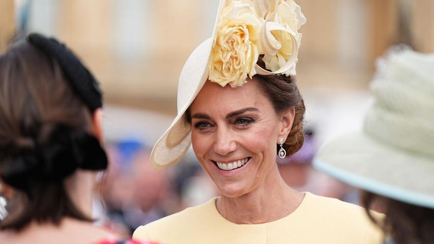 Bei der Gartenparty trug Kate ein pastellgelbes Kleid mit passendem Kopfschmuck, einem sogenannten Fascinator. Bei der Gartenparty trug Kate ein pastellgelbes Kleid mit passendem Kopfschmuck, einem sogenannten Fascinator.