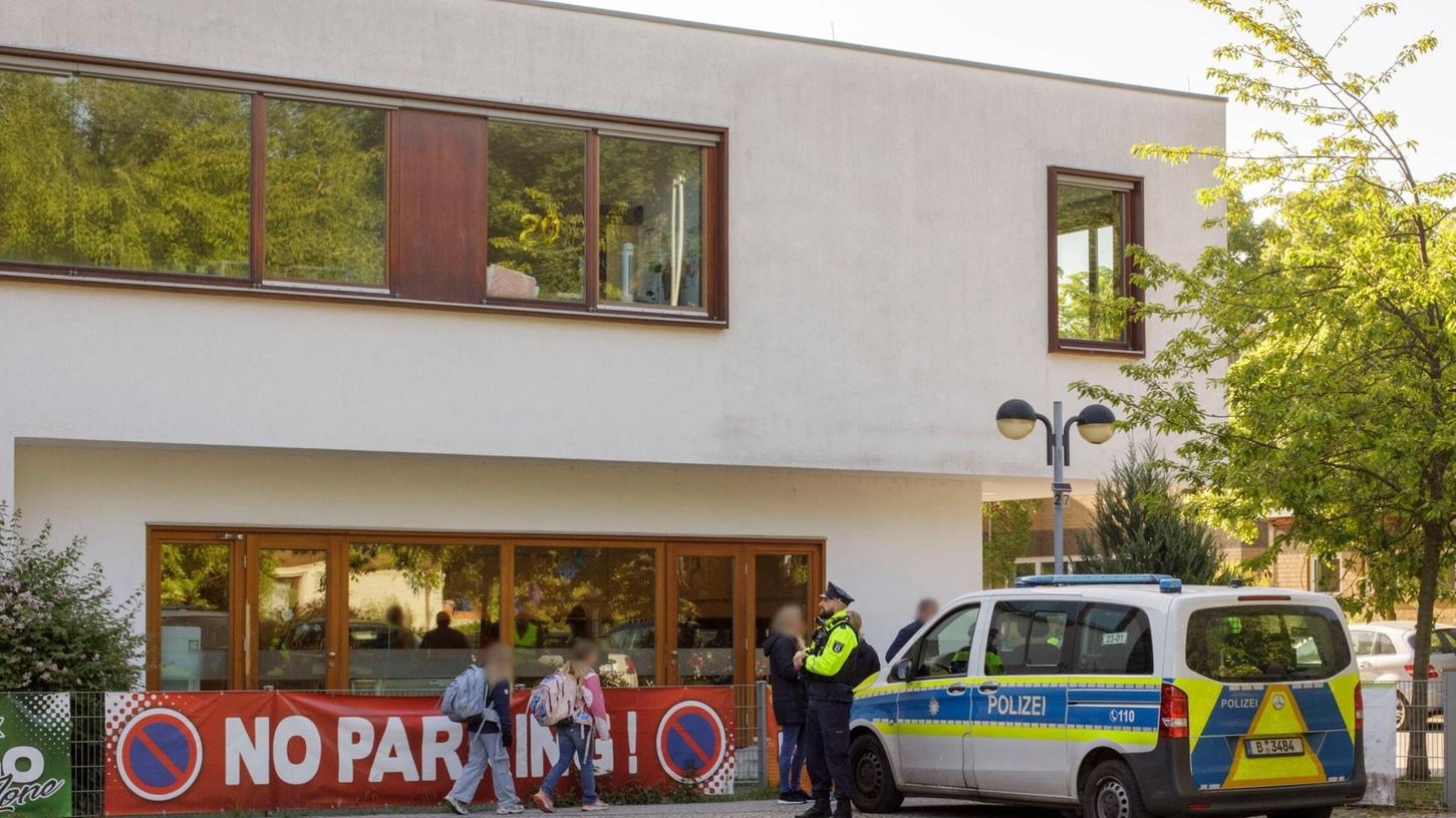 Die Polizei steht vor einer Grundschule im Berliner Bezirk Spandau, während Schüler am Morgen zur Schule kommen. Die Polizei steht vor einer Grundschule im Berliner Bezirk Spandau, während Schüler am Morgen zur Schule kommen.
