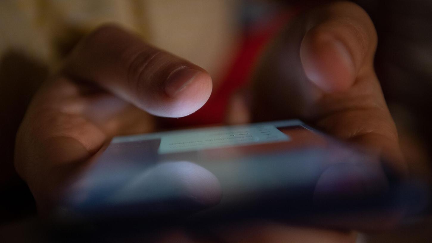 Ein Mensch tippt auf einem Smartphone (Symbolfoto). Ein Mensch tippt auf einem Smartphone (Symbolfoto).